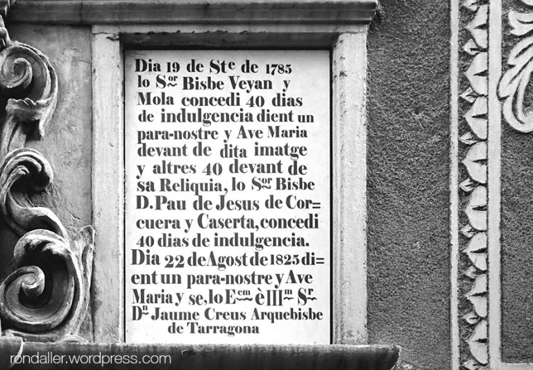 Text per aconseguir indulgències que hi ha a la façana de l'església barroca.