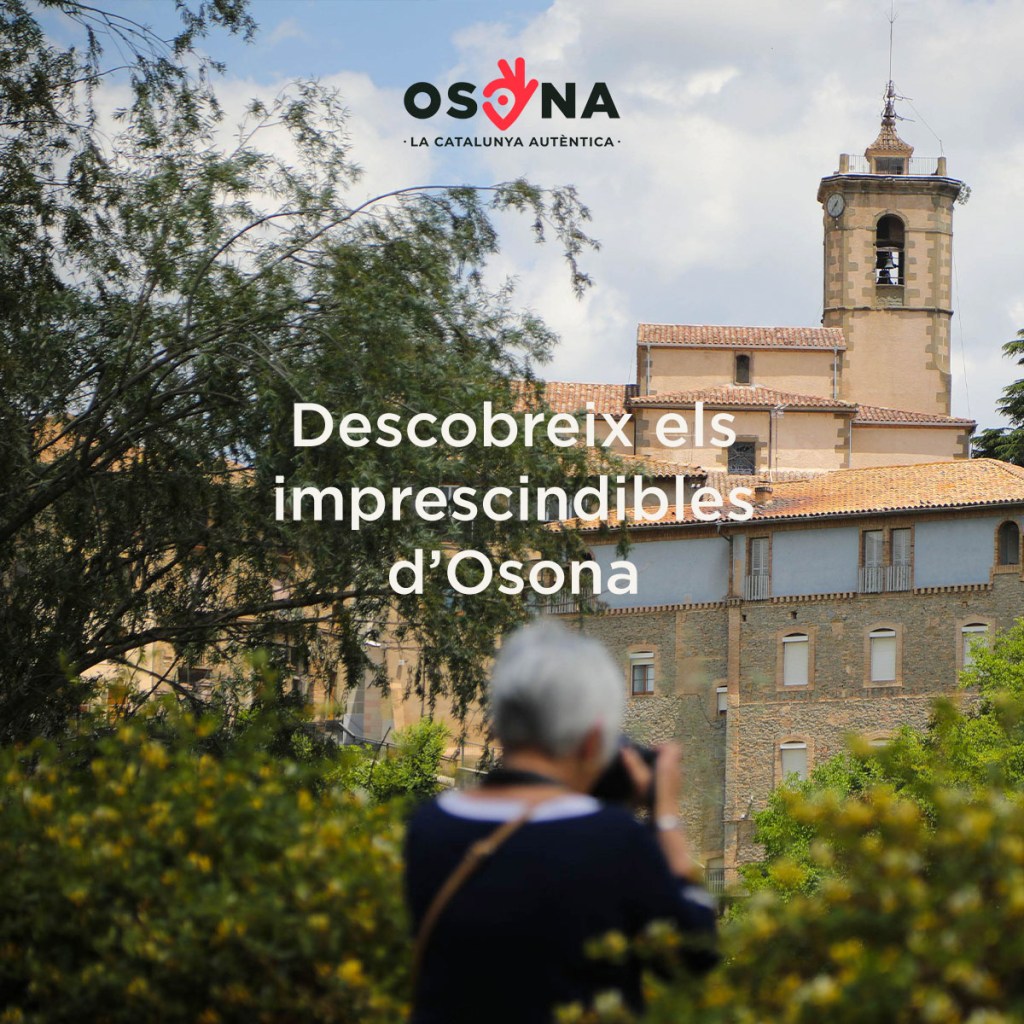 Imatge d'una dona fotografiant una església a la comarca d'Osona.